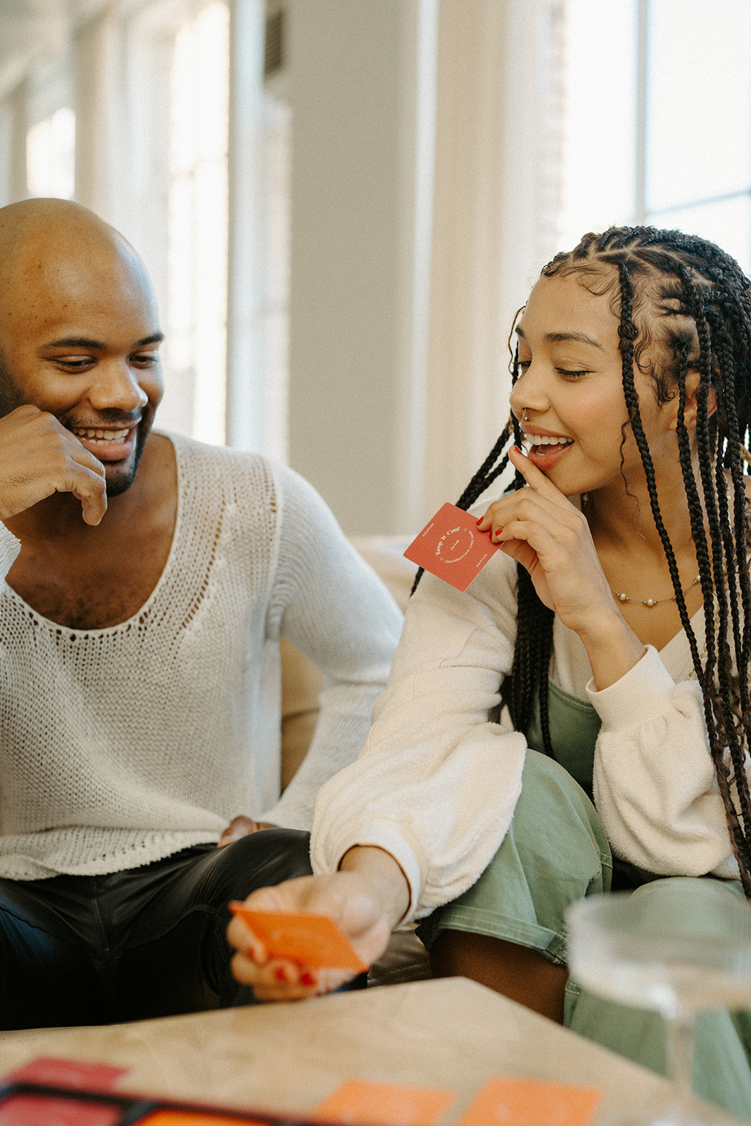 Two couples having fun playing cards